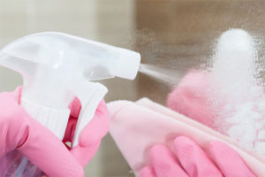 Close up Female Housekeeper Hand Using Spray Bottle For Cleaning Dust on Mirror